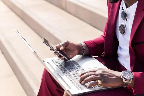 Hands of a black man using phone and computer 写真素材