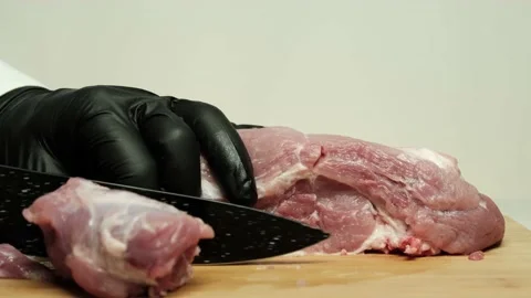 Hands in black protective gloves cutting pork into pieces. Stock Footage 152872254