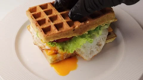 Hands in black silicone gloves squeeze the burger waffles to make the yolk Stock Footage 294564512