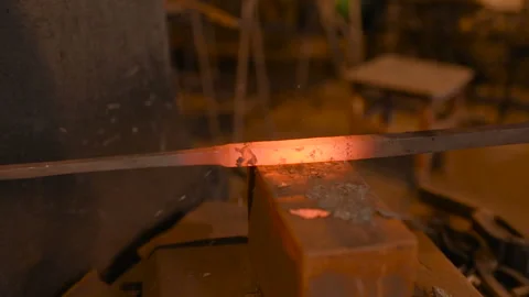 Hands of a blacksmith with a tool on the background of a forge Stock Footage 103752509