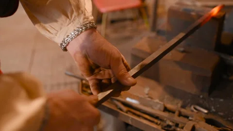 Hands of a blacksmith with a tool on the background of a forge Video stock 116996605