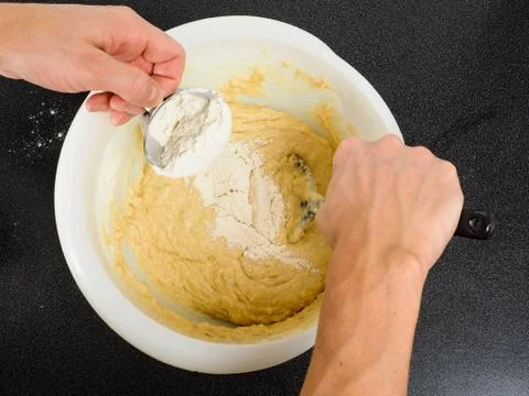 Hands blending flour into a bake mixture Foto stock