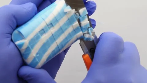Hands in blue gloves are cutting blue white soap. Close-up. Asmr. Vídeos de archivo 293734814