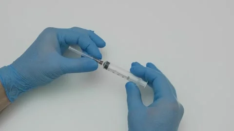 Hands in blue gloves put needle on syringe 스톡 동영상 321745251
