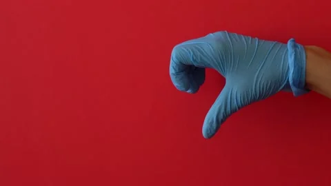 Hands in blue gloves on a red background making heart shape Stock Footage 147371727