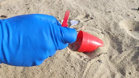Hands in blue gloves remove plastic debris from the sand. The concept of waste m Stock Footage 127150861
