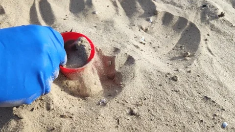 Hands in blue gloves remove plastic debris from the sand. The concept of waste m Stock Footage 127150970