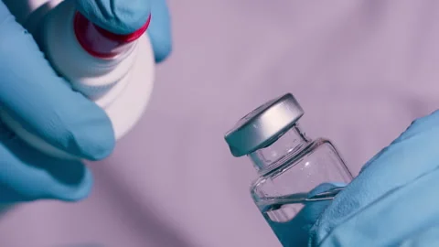 Hands in Blue Gloves Removing Cap from Medical Vial with Liquid 库存影片 338363487
