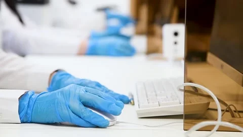 Hands with blue nitrile gloves using a laptop keyboard, performing telework Stock Footage 209145702