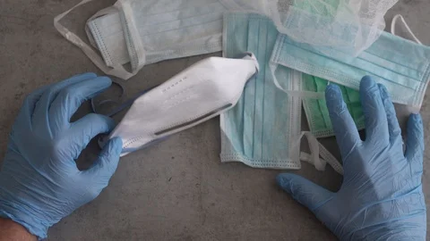 Hands with blue protective gloves holding respirator N95, COVID-19. Stock Footage 127305434