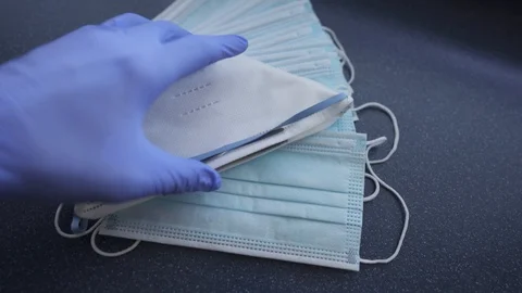 Hands with blue protective nitride gloves holding N95, respirator, face mask Stock Footage 127505735