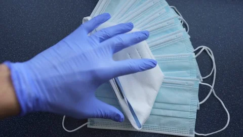 Hands with blue protective nitride gloves holding N95, respirator, face mask Video stock 127506348
