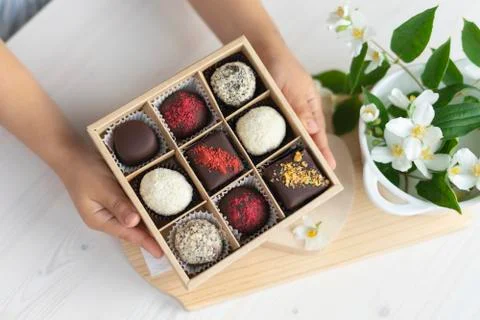 In the hands of a box of chocolates holds. assorted chocolates confectionery in Stock Photos