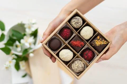 In the hands of a box of chocolates holds. assorted chocolates confectionery in Foto stock