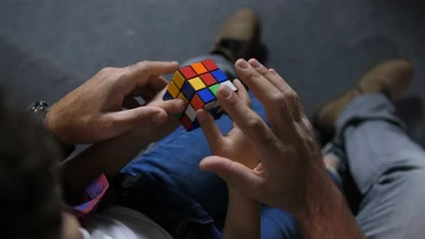 Hands of boy with help of dad collect puzzle cube Stock Footage 100719477