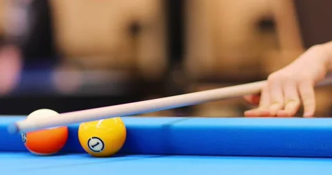 Hands of boy hitting ball by cue during pool training on blue table, close up Stock Footage 276360302