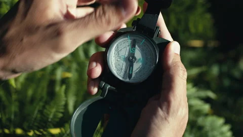 Hands of a boy opens the compass in the mountains to orient himself in the hike Stock Footage 201291557