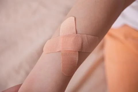 The hands of a boy with a patch of adhesive attached to his hands. Stock Photos