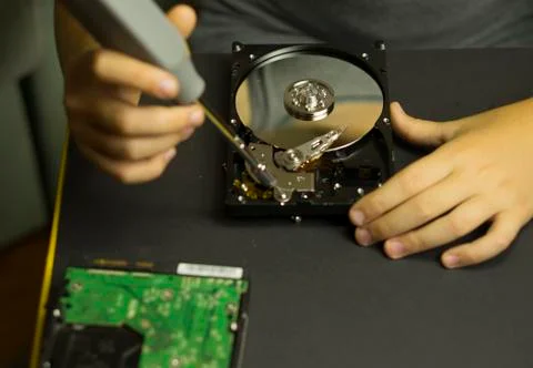 Hands of a boy who disassembles a computer hard drive Stock Photos