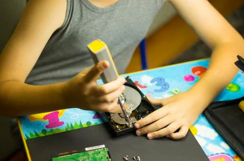Hands of a boy who disassembles a computer hard drive Stock Photos