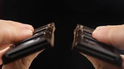 Hands break a bar of chocolate. Slow-motion Video stock 111867241