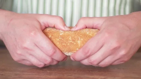 Hands break bread. Harmful carbohydrates. Baker rips fresh bread close-up Видео 131992653