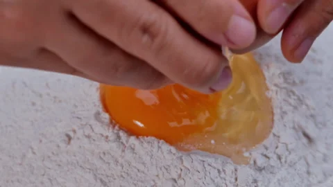 Hands break a chicken egg fall into flour, prepares dough for making donuts. Stock Footage 158092142