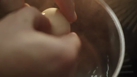 Hands break an egg into boiling water in a saucepan for a poached egg Stock-Footage 150762459