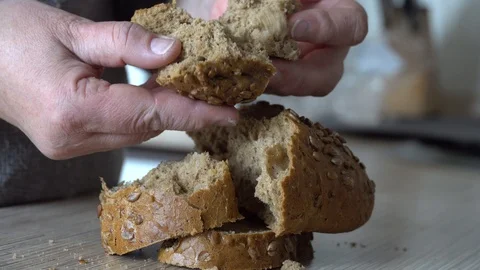 Hands break gray bread into pieces Stock Footage 124211042