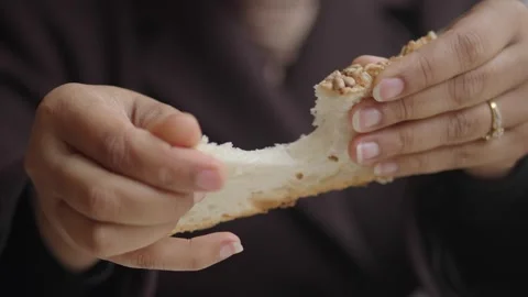 Hands breaking bread in a simple kitchen setting Stock Footage 337811133