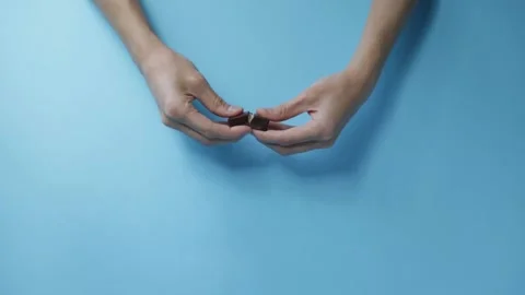 Hands breaking chocolate candy on blue background Stock Footage 160089764