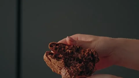 Hands breaking chocolate cookie in half close up Stock Footage 329092989