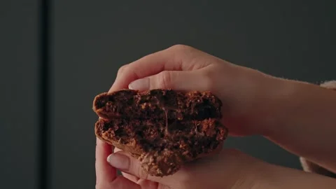 Hands breaking chocolate cookie in half slow motion Stock Footage 332055195