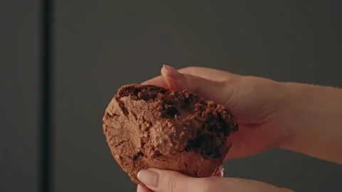 Hands breaking chocolate cookie with melted center Stock Footage 327448696