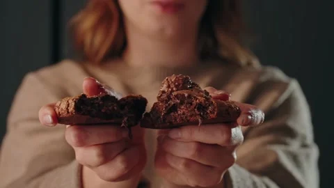 Hands breaking chocolate cookie revealing melted center slow motion Stock Footage 327367340