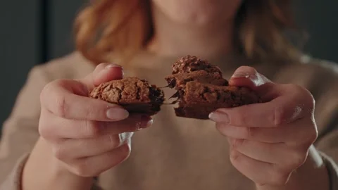 Hands breaking chocolate cookie with soft center indoors Stock Footage 328895177