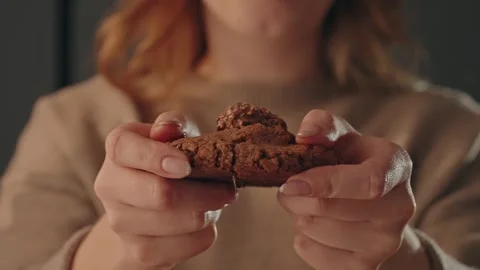 Hands breaking chocolate cookie with soft center indoors Stock Footage 329103395