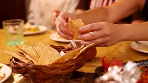 Hands Breaking Crispy Papadum Bread Over Basket in Indian Restaurant Stock Footage 339124239