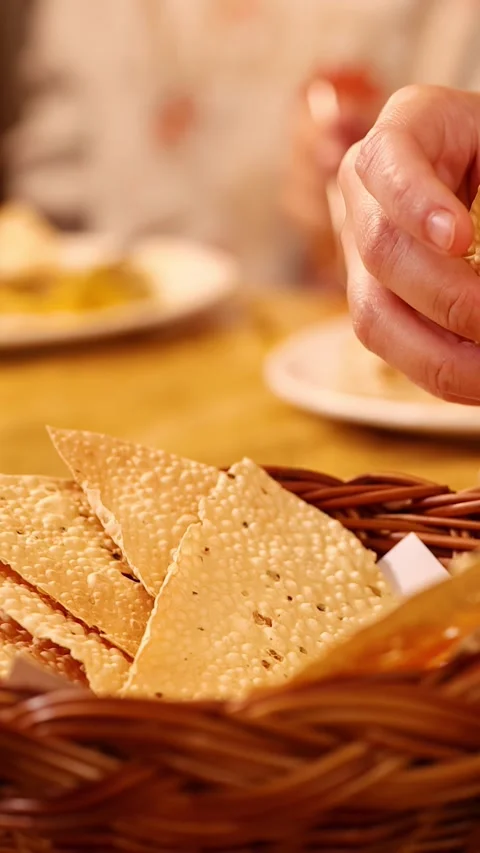 Hands Breaking Crispy Papadum Bread in a Woven Basket at Restaurant Stock Footage 339545910