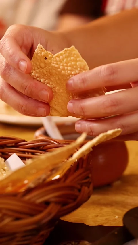 Hands Breaking Crispy Papadum Bread Over Basket in Indian Restaurant Stock Footage 340183132