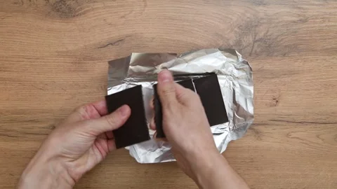 Hands breaking a dark chocolate bar into small pieces 스톡 동영상 317156049