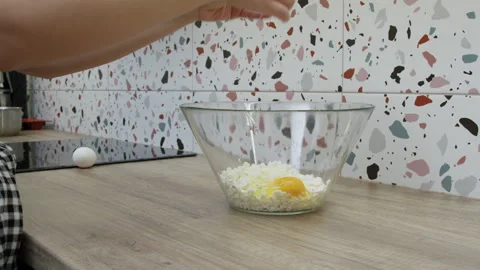Hands breaking an egg into a bowl with pot cheese. Stock Footage 266423957