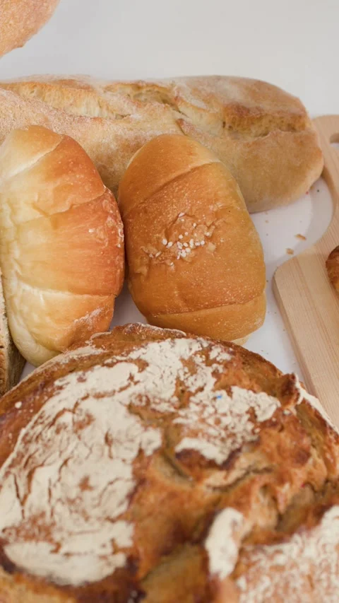 Hands Breaking Fresh Croissant Over Assorted Bakery Breads Stock Footage 337875475