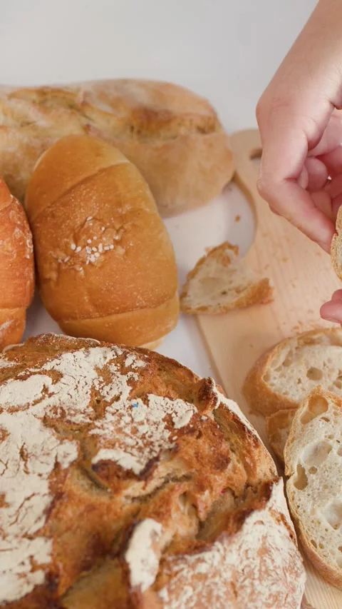 Hands Breaking Fresh Crusty Bread Over Wooden Cutting Board Stock Footage 337532906