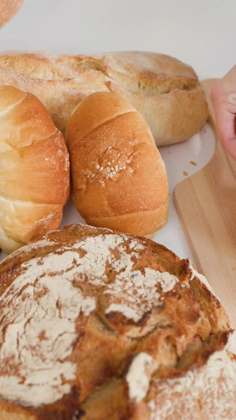 Hands Breaking Fresh Flaky Croissant Near Assorted Artisan Bakery Breads Stock Footage 337520914