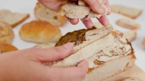 Hands Breaking Fresh Sourdough Bread Over a White Table Stock Footage 337519463