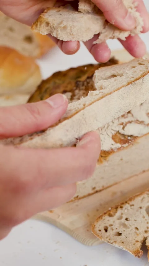 Hands Breaking Fresh Sourdough Bread Loaf on Wooden Board Stock Footage 337747125