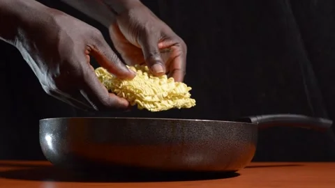 Hands breaking noodles into a pan Stock Footage 276594024