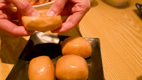 Hands Breaking Open Golden Fried Mantou Bun on Black Plate Stock Footage 337757876