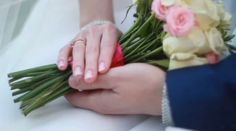 Hands of the bride and groom with rings on a beautiful wedding bouquet Stock Footage 50149535